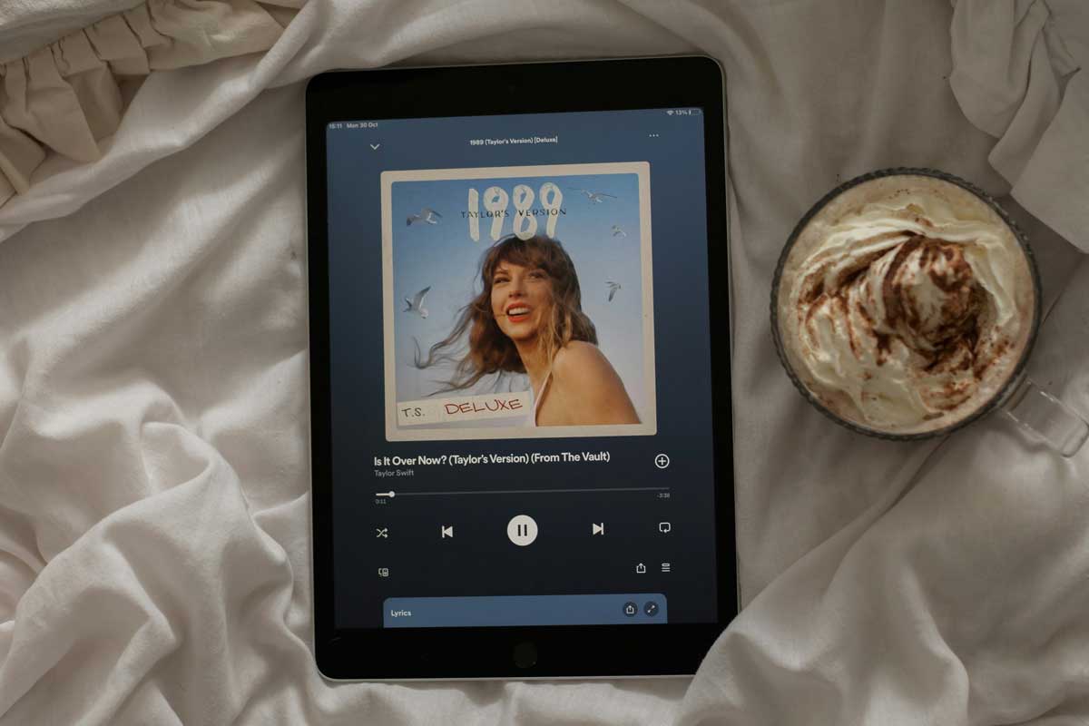 iPad auf weissen Bettbezug mit Spotify offen und Taylor Swift Album Cover 1989